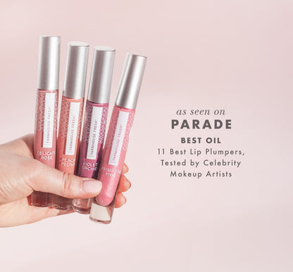 Four lip gloss tubes held by a hand against a pink background with text about best lip plumpers for Parade media mention.