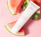 A tube of FarmHouse Fresh Blissed Moon Dip Back To Youth Ageless Mousse for hands on top of watermelon slices that represent the all-natural scent of juicy watermelon and fresh basil.