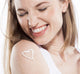 A woman with Buttermilk Lavender Steeped Milk Lotion® for hands by FarmHouse Fresh in shape of a heart on her arm.