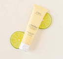 A tube of lightweight Citrine Beach® hand cream by Farmhouse Fresh on top of lime slices.