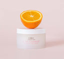 A jar of FarmHouse Fresh C of Change Clinical Peel Pads with half an orange on top of it, representing the natural ingredients of this skincare product.