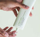 Person’s hands squeezing a dab of FarmHouse Fresh’s all-natural Crisp Start Clarifying Face Wash on their hands, showing its clear gel consistency. 
