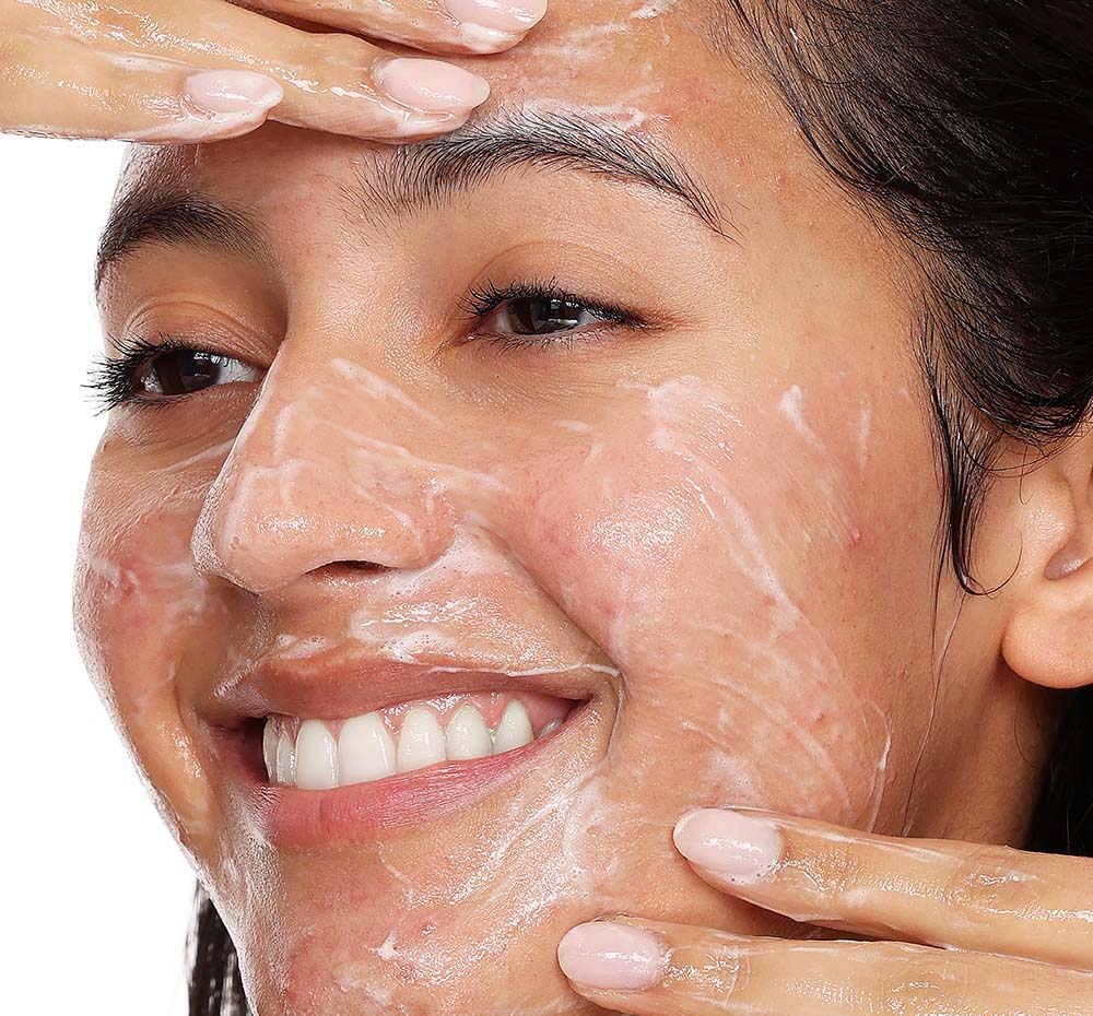 A woman is washing her face with FarmHouse Fresh’s all-natural Crisp Start Clarifying Face Wash to clear acne and achieve a smooth, balanced and freshly clean complexion.