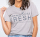 A woman wearing a grey FarmHouse Fresh Donation T-Shirt, showcasing her support for FHF Sanctuary.