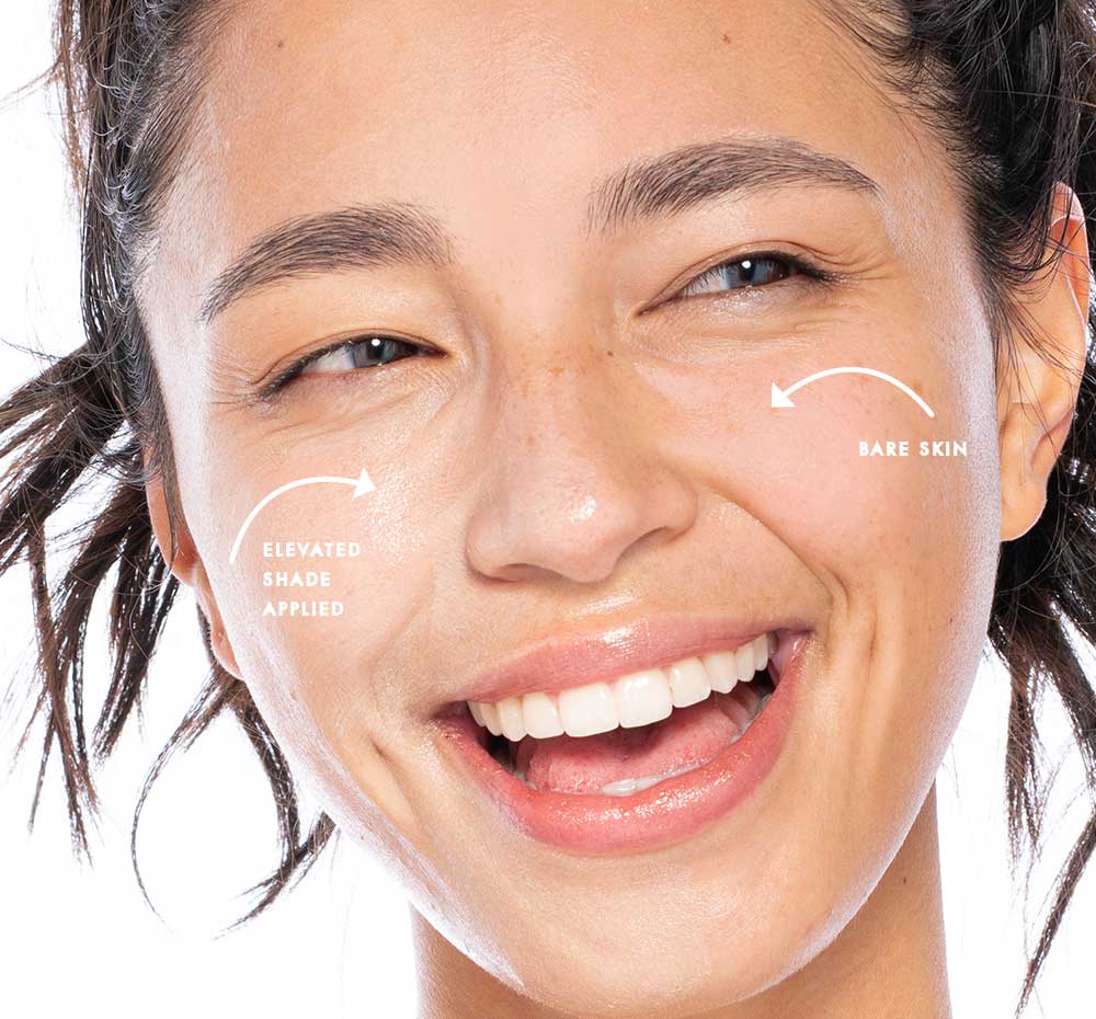 A woman's face with a radiant smile, showcasing her skincare superpowers with a hint of Elevated Shade® tinted mineral sunscreen by Farmhouse Fresh.