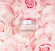 A jar of FarmHouse Fresh Evening Rose Moon Dip Ageless Facial Sleep Mousse with Peptides and Retinol on top of rose petals.