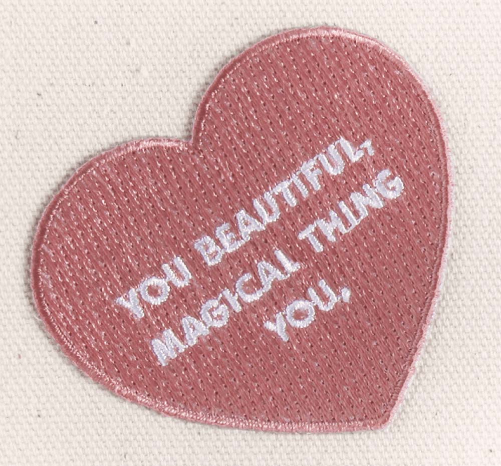 A heart shaped patch that says you beautiful magical thing, which comes on a FarmHouse Fresh® Gifting Tote.