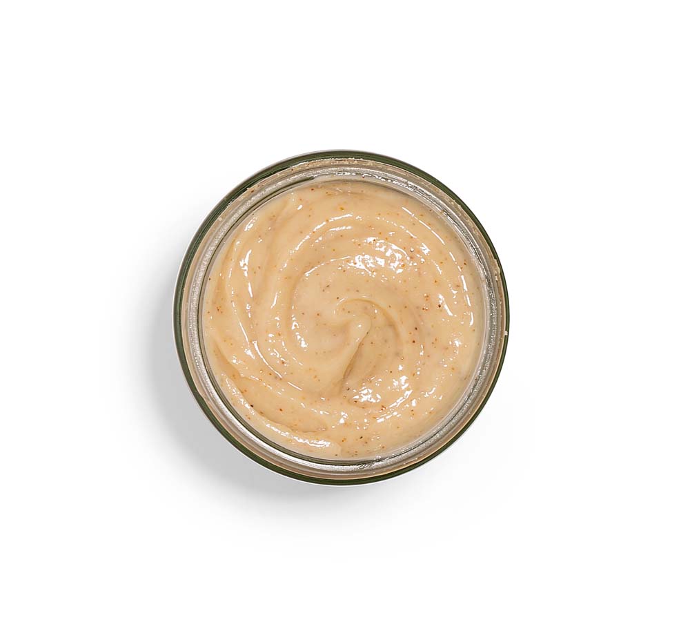 Top view of an opened jar of Finely Awake Plantfoliant Silkening Face Cleansing Polish by FarmHouse Fresh showing its grainy, exfoliating texture.