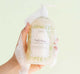 A hand holding FarmHouse Fresh Fluffy Bunny Soothing Body Wash made with skin calming botanical extracts like green tea and chamomile.