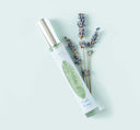 A Fluffy Bunny Travel Spray Perfume with a long-lasting scent, next to a lavender flower.