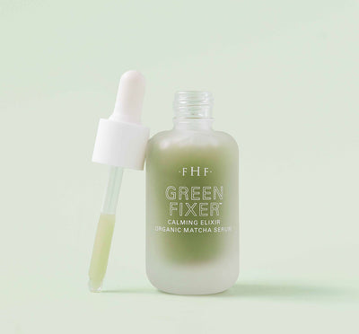 A bottle with a dropper of FarmHouse Fresh Green Fixer Calming Elixir Organic Matcha Face Serum that visibly reduces the look of redness.