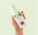 A hand holding a bottle of gentle Green Tea face wash from Farmhouse Fresh.