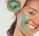 A woman with a Farmhouse Fresh Guac Star hydrating avocado face mask on her face.