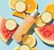 A bottle of FarmHouse Fresh Illumination Juice Facial Toner surrounded by fruit slices.