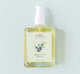 A bottle of Juniper Ale body oil by FarmHouse Fresh scented with fresh greens and bergamot orange.