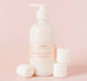 A bottle of FarmHouse Fresh’s nourishing Marshmallow Melt Shea Butter for body for dry skin with marshmallows next to it.