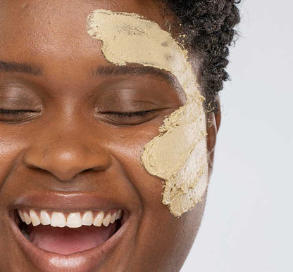 A woman with Matcha Purity Mask by FarmHouse Fresh on her face, a calming and clearing face mask made with locally sources soothing ingredients.