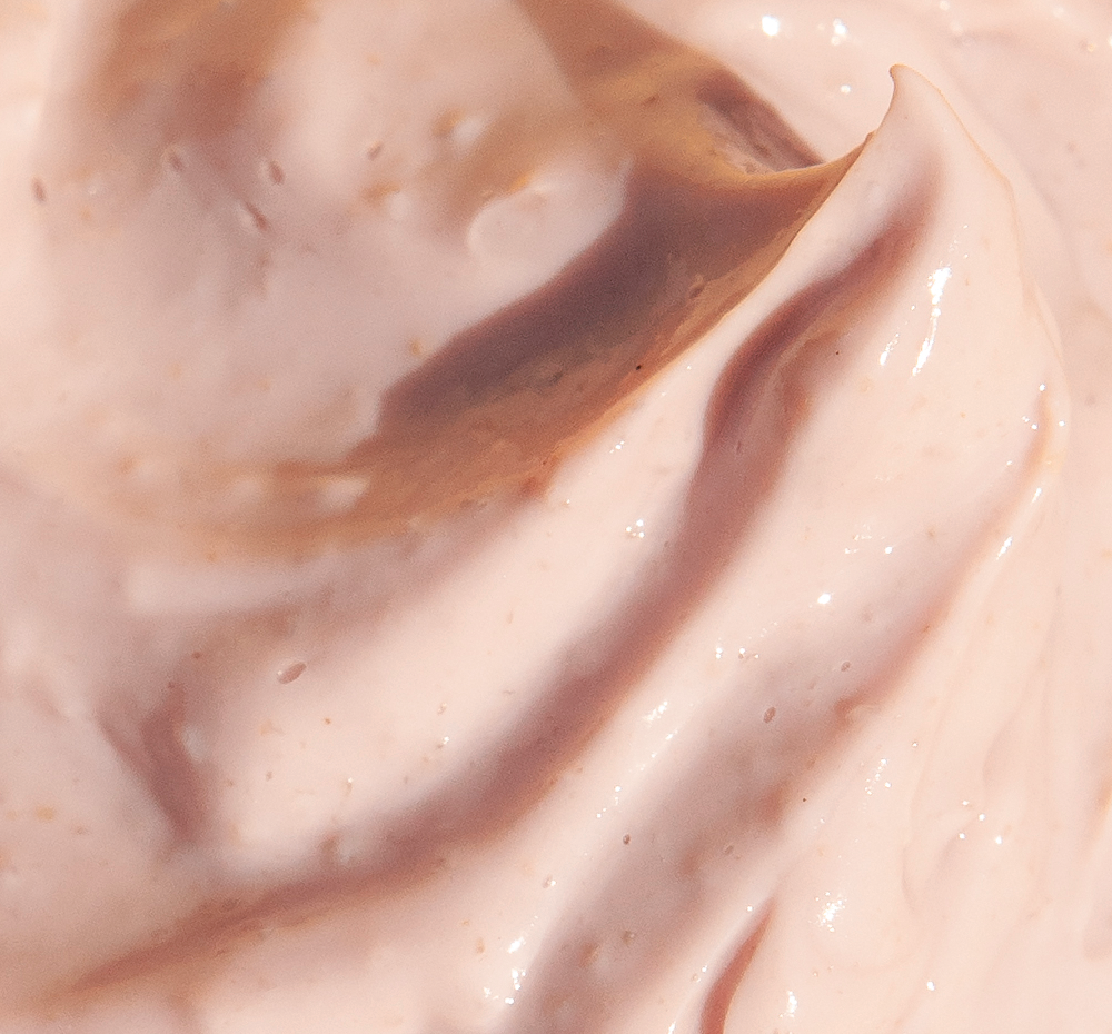 A close-up of the creamy texture of FarmHouse Fresh Mighty Brighty Vitamin C + Chamomile Brightening Mask that leaves skin bright and fresh.