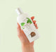 A hand holding a bottle of gentle Green Tea face wash from Farmhouse Fresh.