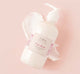 A Pink Moon shea butter body lotion and a texture smudge on a pink background.