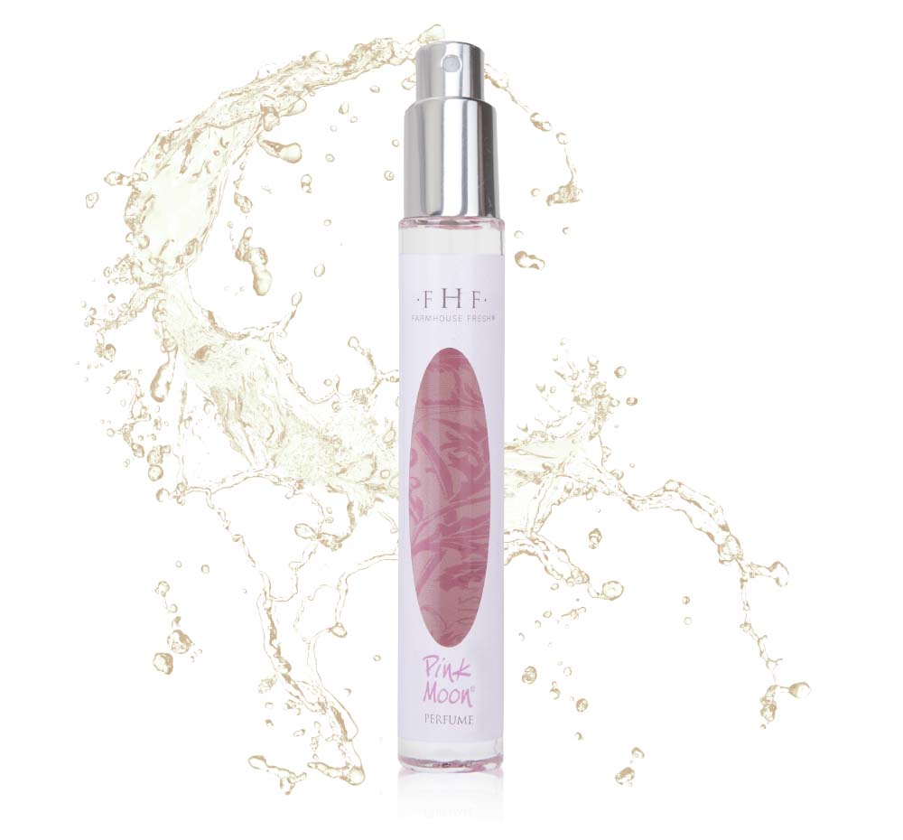 A bottle of Farmhouse Fresh perfume with a splash of water, exuding the soft licorice blossom, powder and spun sugar scent of Pink Moon Travel Spray.