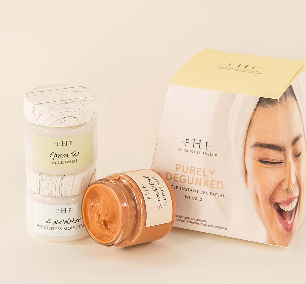 Three jars with skincare products from Purely Degunked Instant Spa Facial by FarmHouse Fresh with a box next to them. Includes a face cleanser, purifying pumpkin face mask and a face moisturizer.