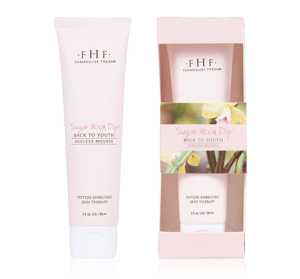 A tube and a box of FarmHouse Fresh Sugar Moon Dip Back To Youth Ageless Mousse for Hands made with advanced peptides and youth-restoring ingredients that visibly firm the look of skin.