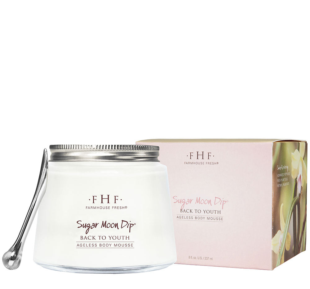 A box and a jar of Sugar Moon Dip Body mousse with an application wand, a light moisturizing body cream with anti-aging ingredients like firming peptides and retinol.