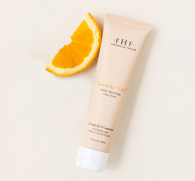 A tube of FarmHouse Fresh Sunshine Silk Shea Butter for hands scented with a light, uplifting blend of creamy vanilla and juicy tangerines.