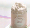 A jar of natural plant-based Timescape Micromazing Face Polish by Farmhouse Fresh sitting on top of a shiny surface; an anti-aging exfoliator for a glowing complexion.
