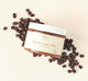 Triple Shot Caramel Coffee Whipped Shea Butter Body Polish by FarmHouse Fresh on top of coffee beans, one of the main ingredients in this natural body scrub.
