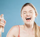 A woman smiling after misting her face with Vitamin Berry Facial Tonic FarmHouse Fresh, a refreshing face toner for dry skin that erases the appearance of enlarged pores.