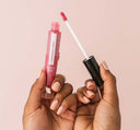 A hand holding FarmHouse Fresh Vitamin Glaze Oil Infused Lip Gloss in Sheer Pink color.