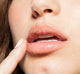 A close up of a woman exfoliating her lips with Farmhouse Fresh Whoopie lip polish with a sweet scent of buttercream cake.