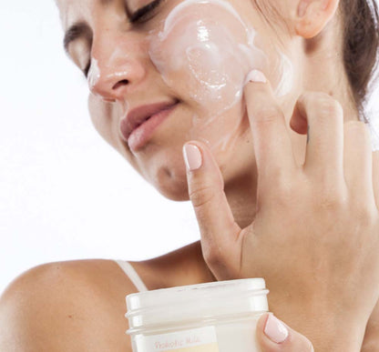 A woman is applying Will Dew Organic Probiotic Milk Balancing Mask by FarmHouse Fresh on her face to reduce dryness, redness and the look of wrinkles.