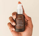 A hand holding Wine Down Overnight Super Antioxidant Recovery Serum by FarmHouse Fresh.