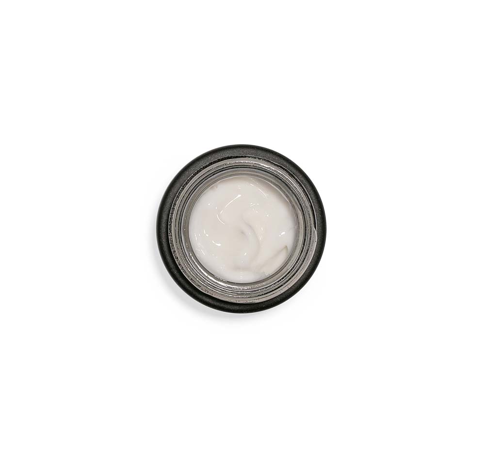 Top view of an opened jar of Crow Catcher wrinkle-fighting serum on a white background.